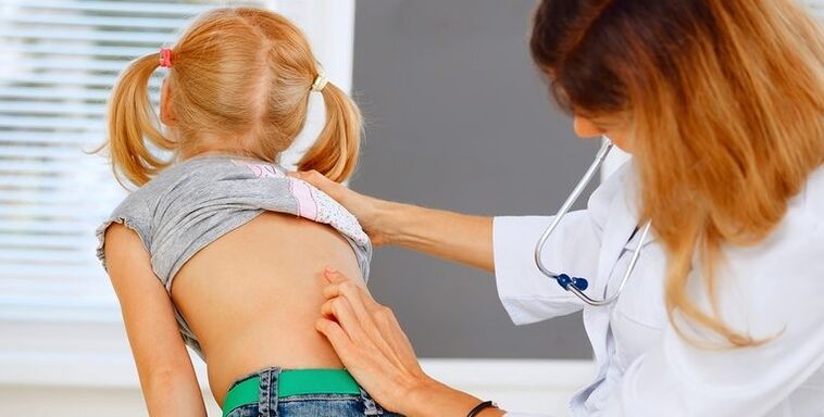 doctor examining a child's back for back pain